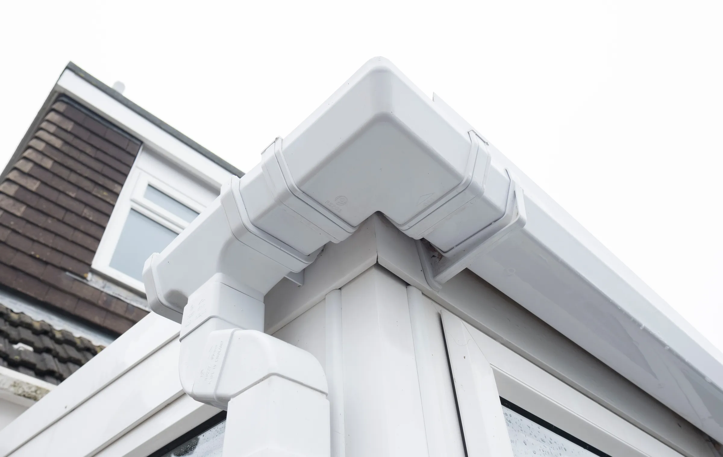 White uPVC guttering and downpipe on a brick property